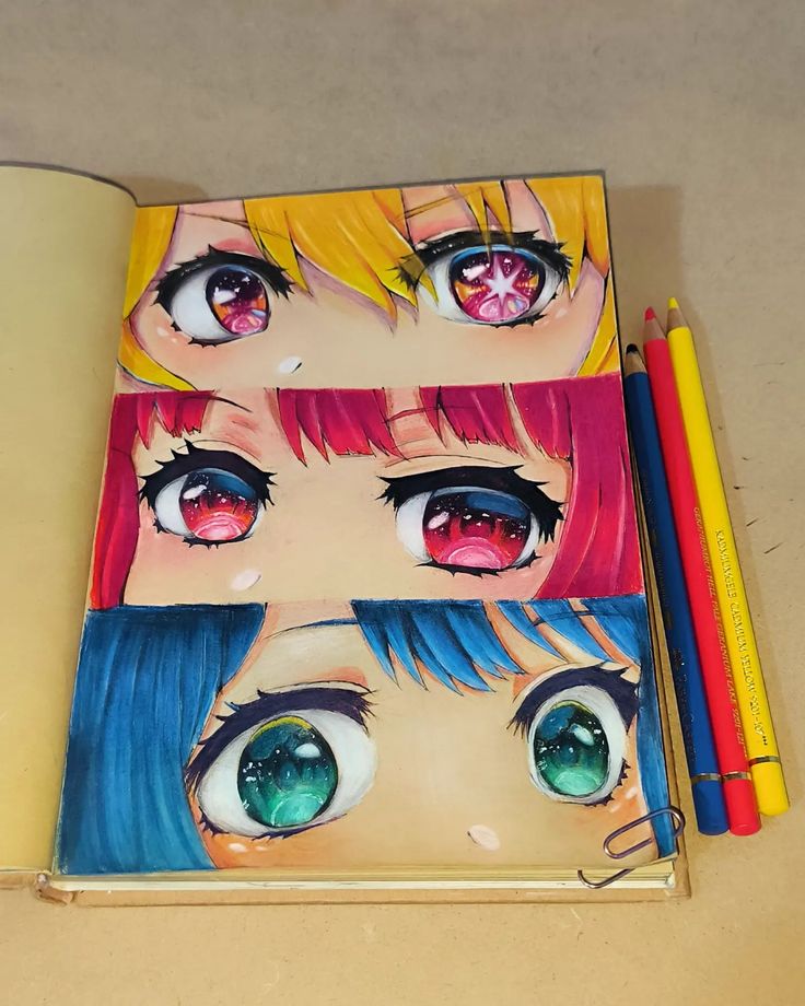 Anime eye art in sketchbook with colored pencils; vibrant designs showcase red, yellow, and blue hairstyles.