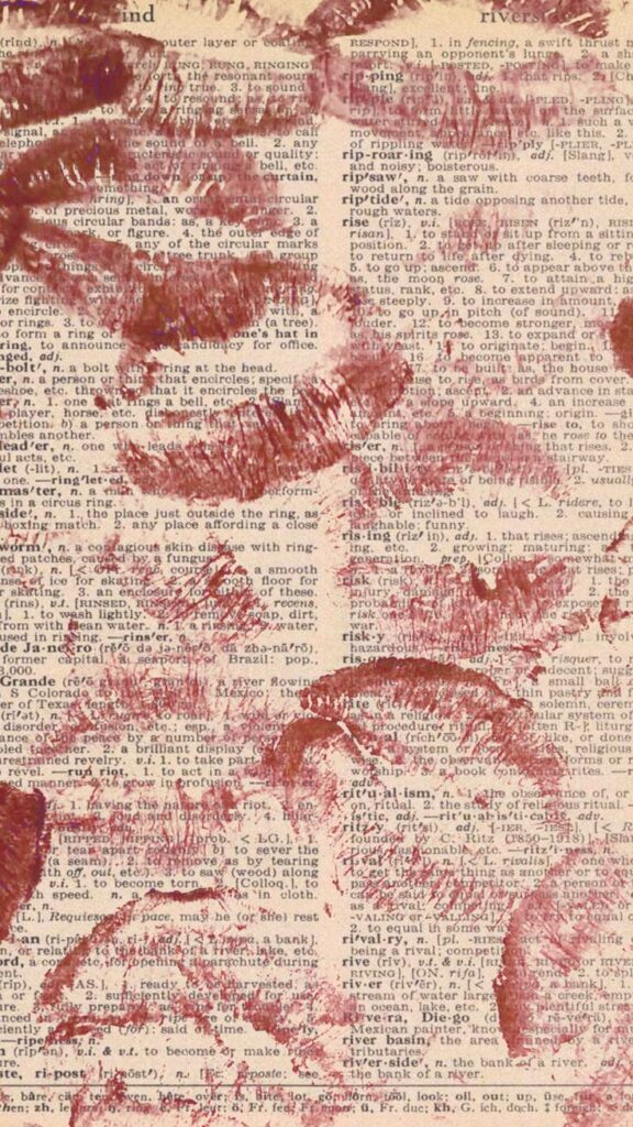 Red lipstick marks on a vintage dictionary page, creating a nostalgic and artistic contrast.