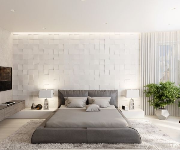 Modern bedroom with textured wall, grey bed, and cozy decor, featuring plants and soft lighting for a serene ambiance.