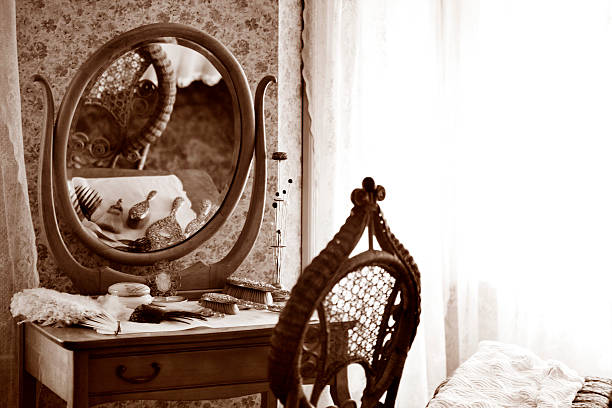 Vintage vanity table with ornate mirror, elegant brush set, and soft light filtering through lace curtains.