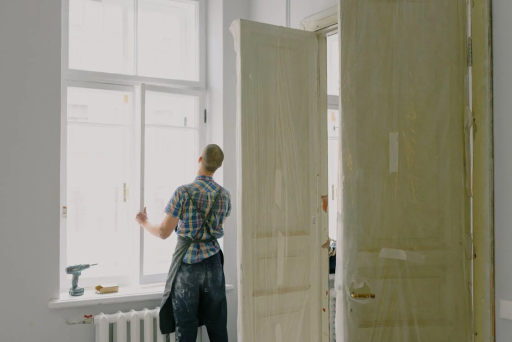 worker fixing windows in home