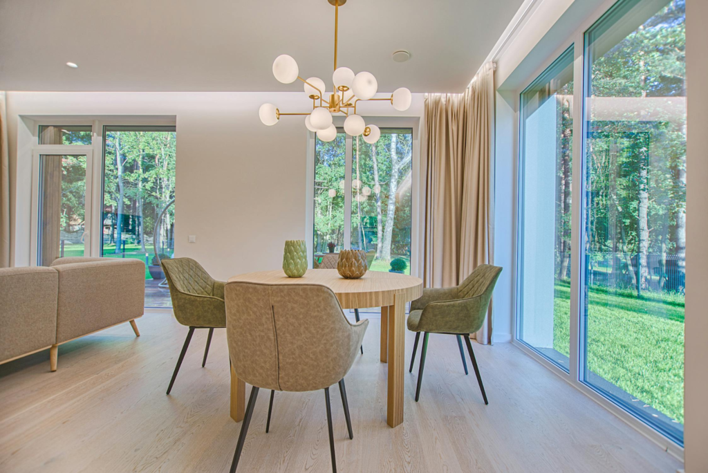 Modern dining room with large windows, elegant lighting, and stylish furniture in a bright, serene setting.