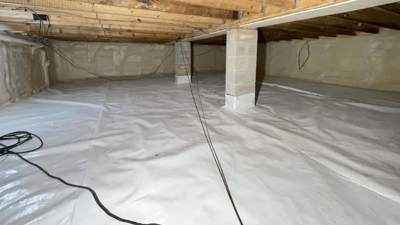 Sealed crawl space with vapor barrier lining, preventing moisture and improving home insulation.