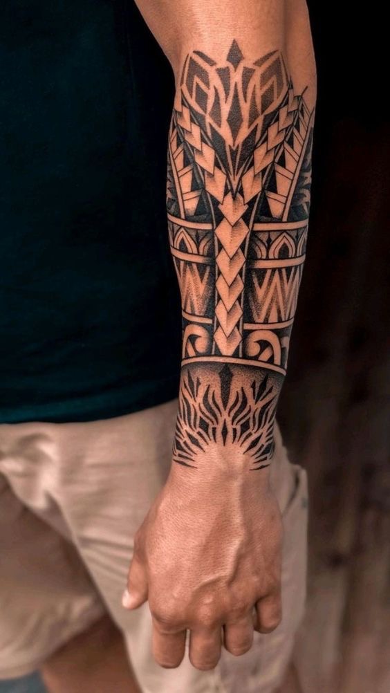 Intricate tribal forearm tattoo design featuring bold geometric patterns and shapes.