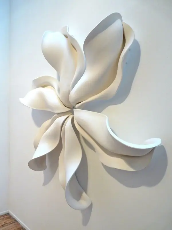 Abstract white wall sculpture with flowing, petal-like shapes, creating an organic and dynamic art piece.