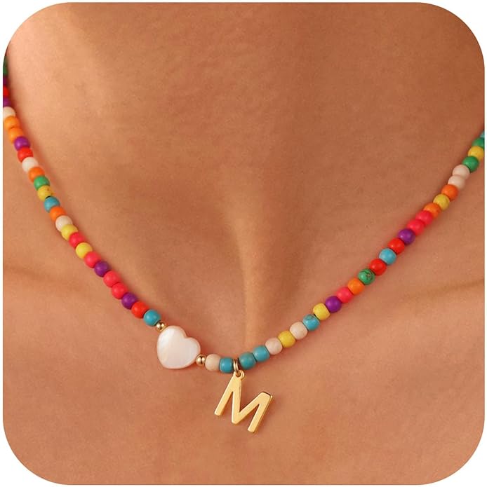 Colorful beaded necklace with heart charm and M initial pendant resting on skin.