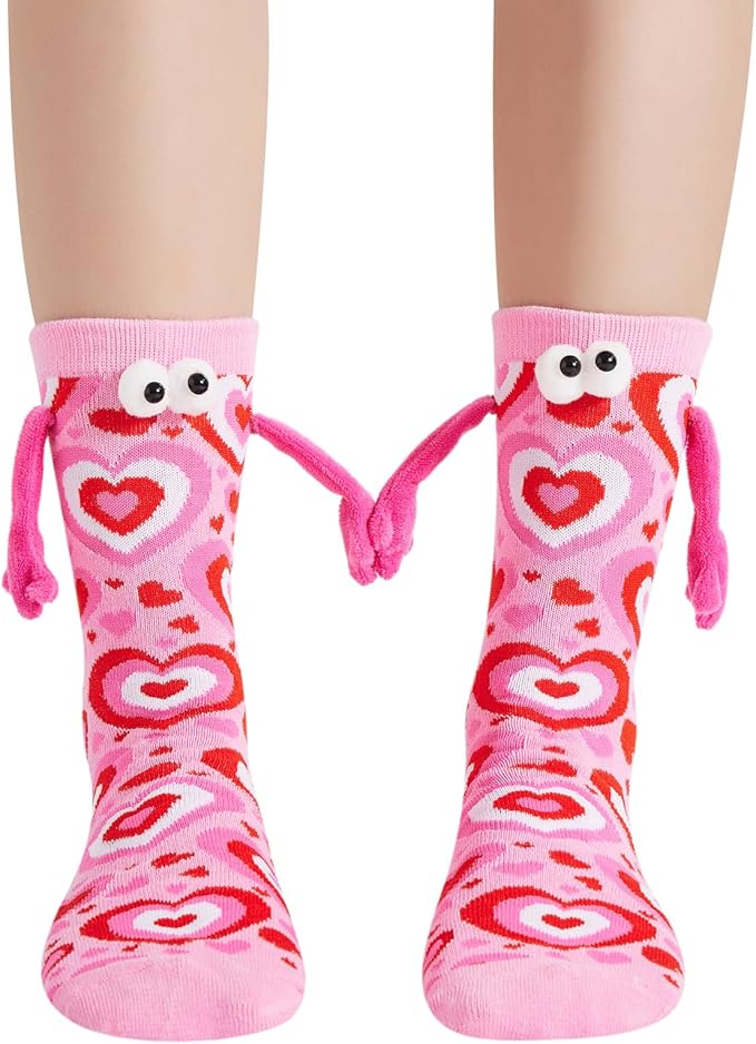 Pink heart-patterned socks with playful eyes and string arms, creating a fun and cozy design for kids.