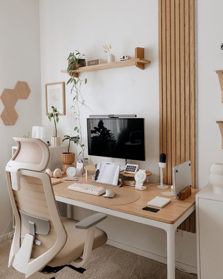 Minimalist home office with wooden desk, ergonomic chair, computer, decor, and plants for a cozy workspace setup.