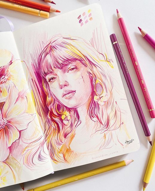 Colorful portrait sketch of a woman with pencils scattered nearby in a sketchbook, featuring floral detail.