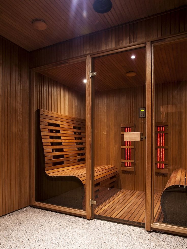 Luxurious wooden sauna room with benches and infrared heaters, offering a relaxing spa experience.