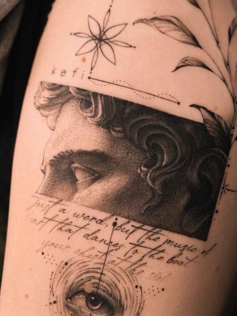 Tattoo art featuring a detailed eye, Greek word kefi, intricate floral and geometric designs on skin.