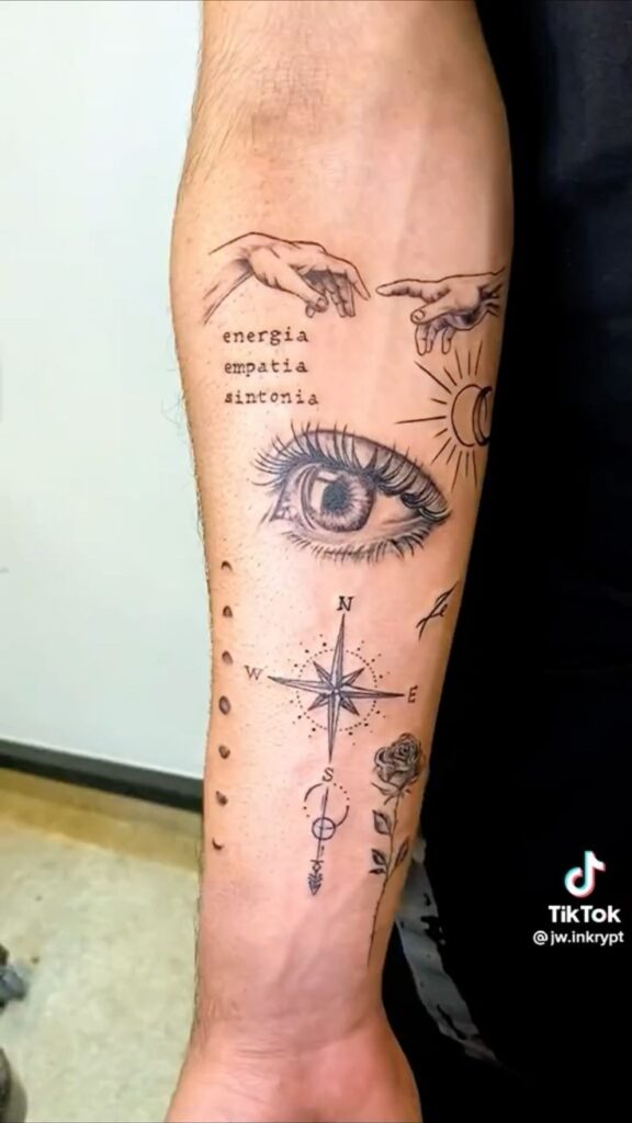 Forearm tattoo with eye, compass, rose, and hands, featuring words energia, empatia, and sintonia.