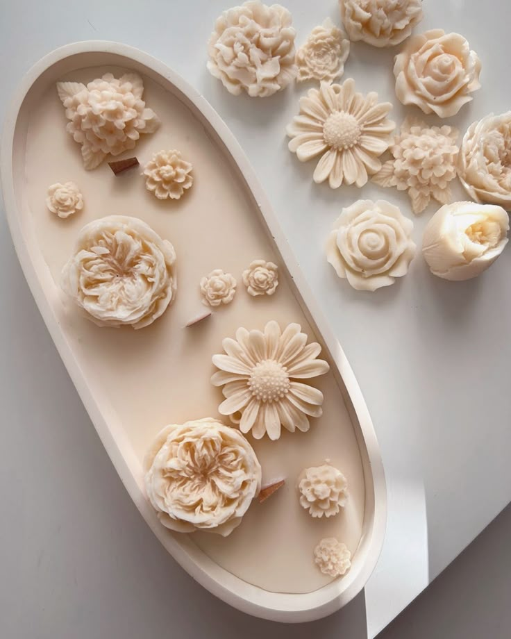 Intricate floral soap designs on a white tray, showcasing detailed craftsmanship and elegant decoration.