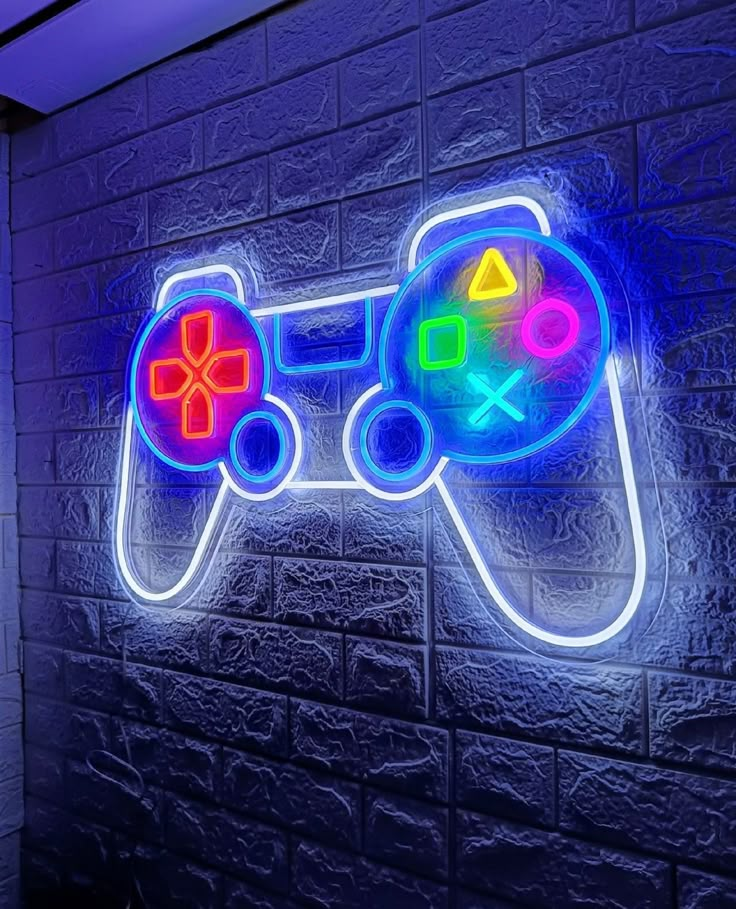 Neon gaming controller sign on a brick wall, brightly lit in blue and multicolored buttons. Perfect for gaming decor.