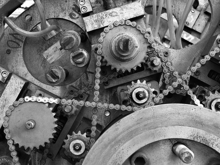 Close-up of mechanical gears and chains in a vintage machine, showcasing engineering intricacy and industrial design.