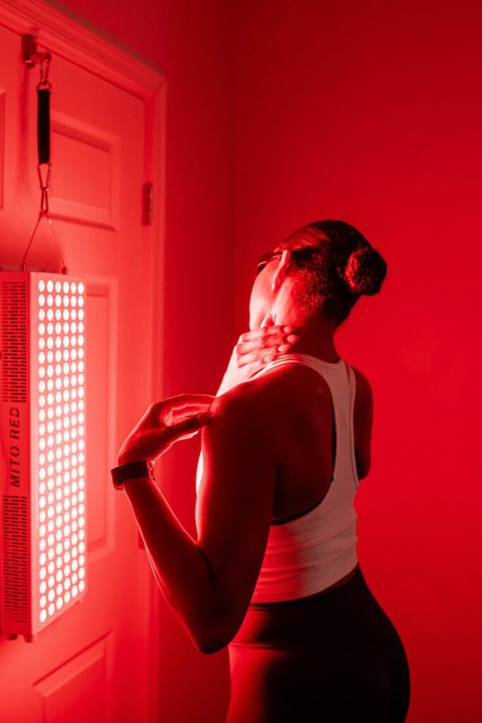 Person using red light therapy in room for relaxation and wellness benefits.