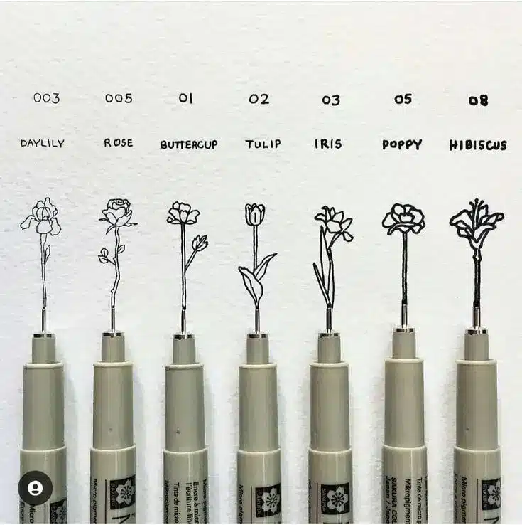 Fineliners with floral drawings of daylily, rose, buttercup, tulip, iris, poppy, and hibiscus, showcasing precision art.