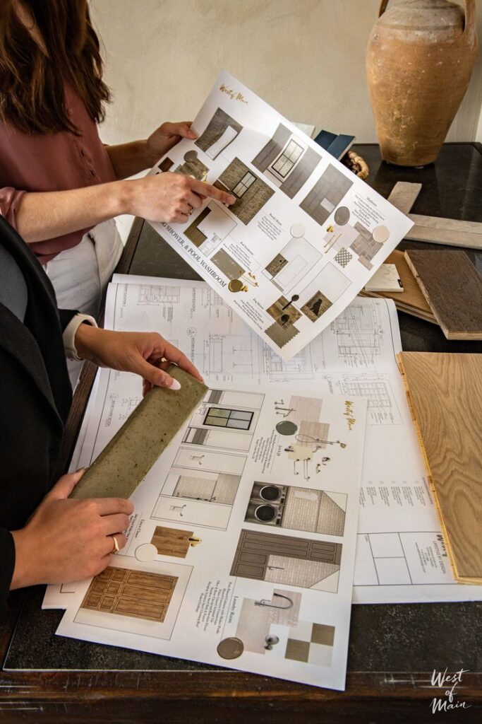 Two designers reviewing architectural plans and material samples for an interior renovation project.