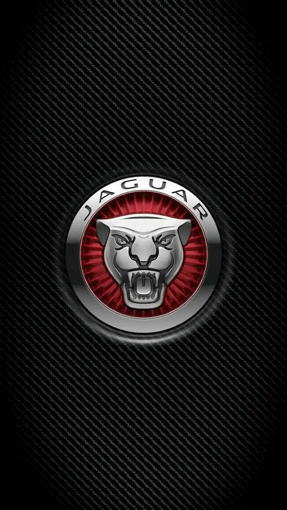 Jaguar emblem with a fierce animal face on a carbon fiber textured background, highlighting luxury and performance.