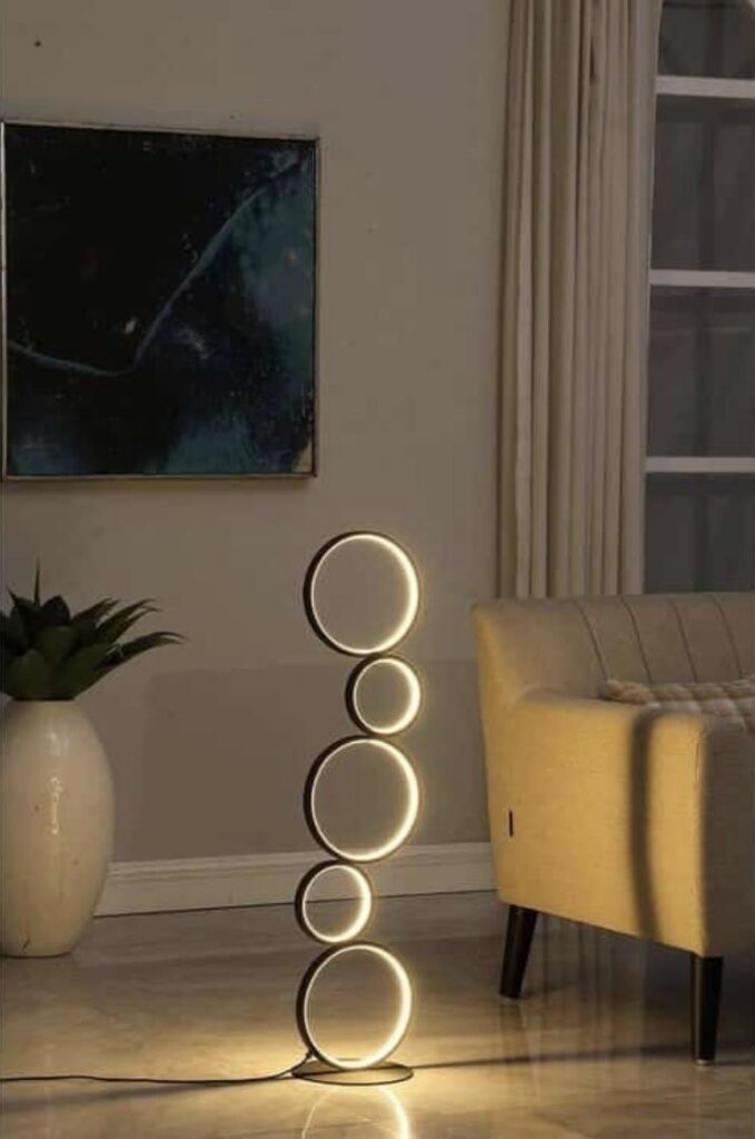 Lamps Design 5 Modern floor lamp with circular LED lights in a cozy living room with artwork and beige sofa. | Sky Rye Design Modern floor lamp with circular LED lights in a cozy living room with artwork and beige sofa.