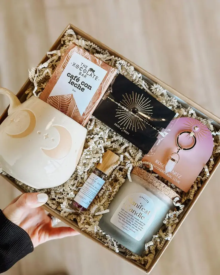 Manifest your dreams ✨ Gift box with candle, mug, chocolate, bracelet, and aromatherapy oil on shredded paper filler in a natural color. | Sky Rye Design Gift box with candle, mug, chocolate, bracelet, and aromatherapy oil on shredded paper filler in a natural color.