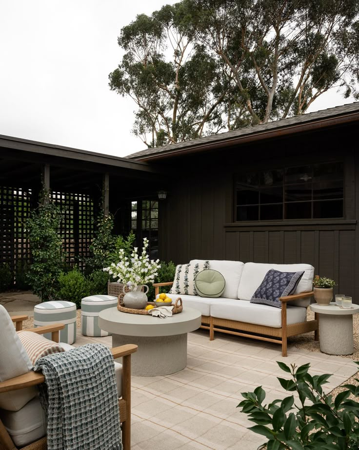 Chic outdoor patio with modern furniture, lush greenery, and cozy decor for a relaxing backyard retreat.