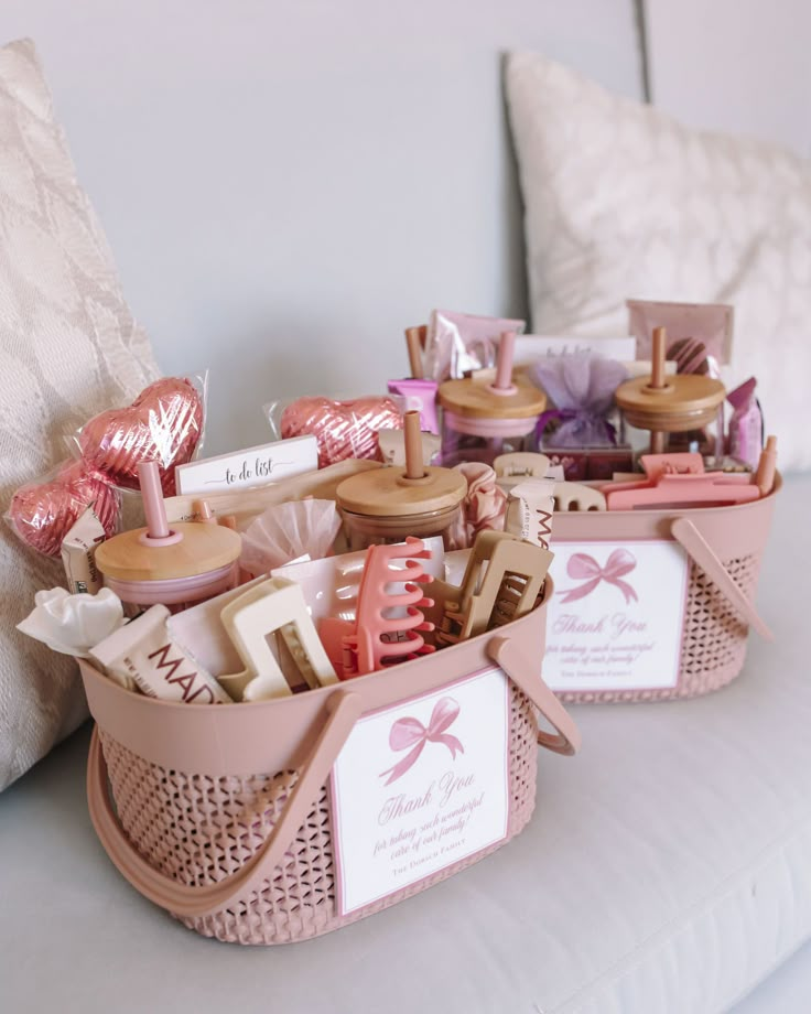 Gift baskets with pink and beige beauty products on a couch cushion, perfect for a thoughtful thank you gesture.