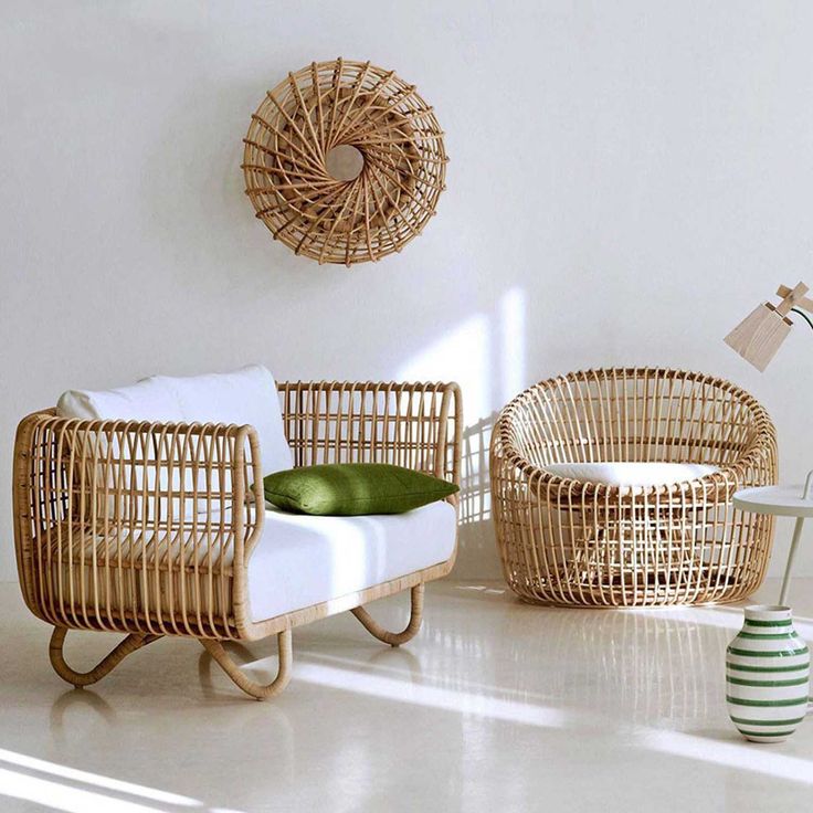 Modern rattan furniture set with a green cushion, wall decor, and lamp in a bright room. Scandinavian style.