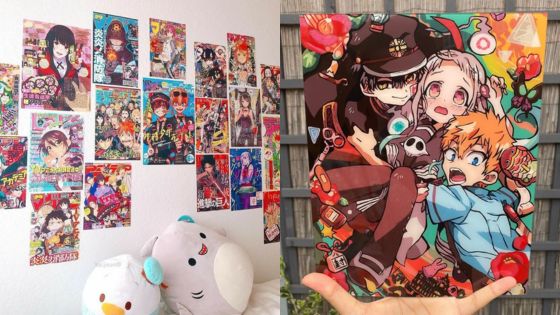 Colorful anime posters on a white wall with plush toys and a vibrant manga-style art piece held up.