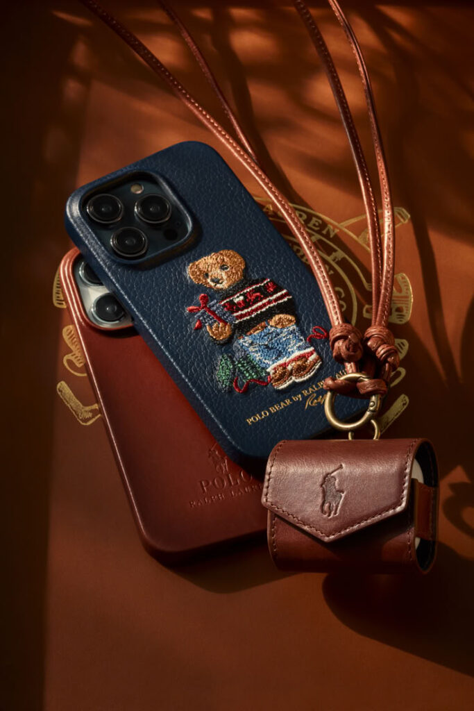 Designer phone cases with embroidered bear on leather, displayed with a stylish leather pouch and strap.