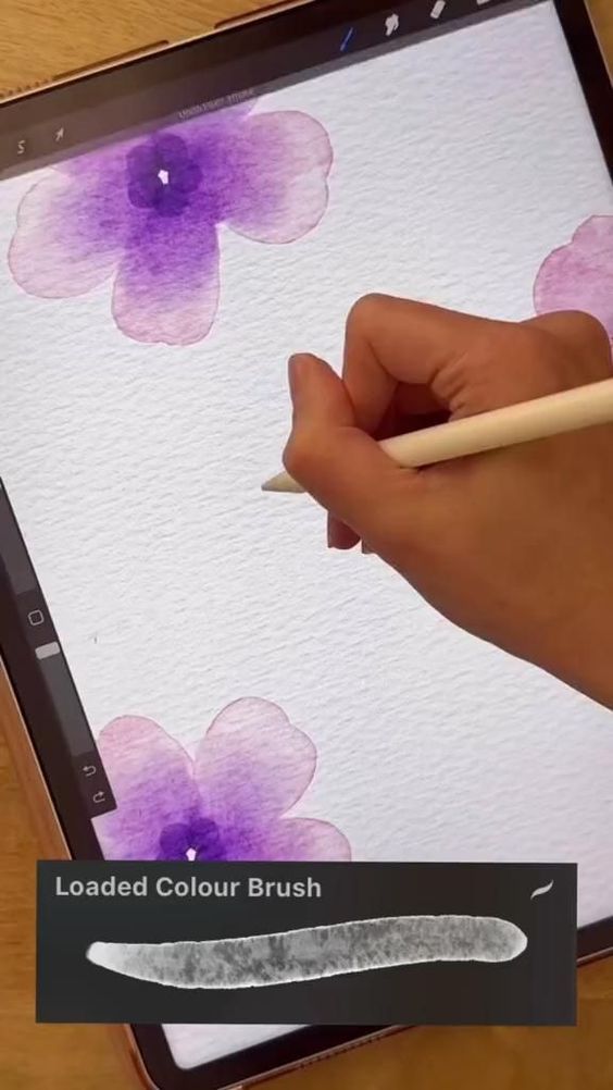 Digital painting on tablet: hand drawing purple flowers with stylus using loaded color brush tool.