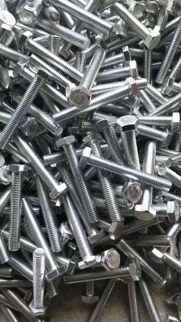 Pile of shiny metal hex bolts, ideal for construction and engineering projects.