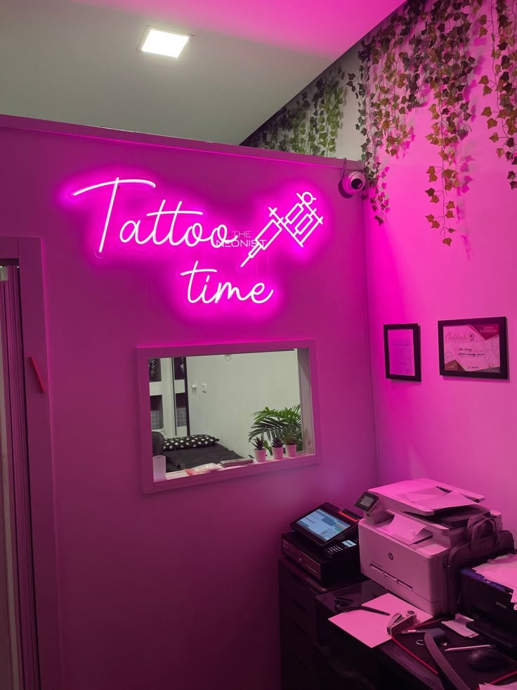 Neon pink Tattoo time sign in a tattoo studio with ivy decoration and modern workspace.