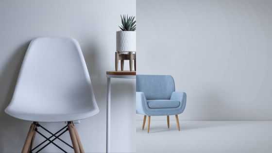 Minimalist room with white chair, small plant on stand, and light blue armchair against a gray background.