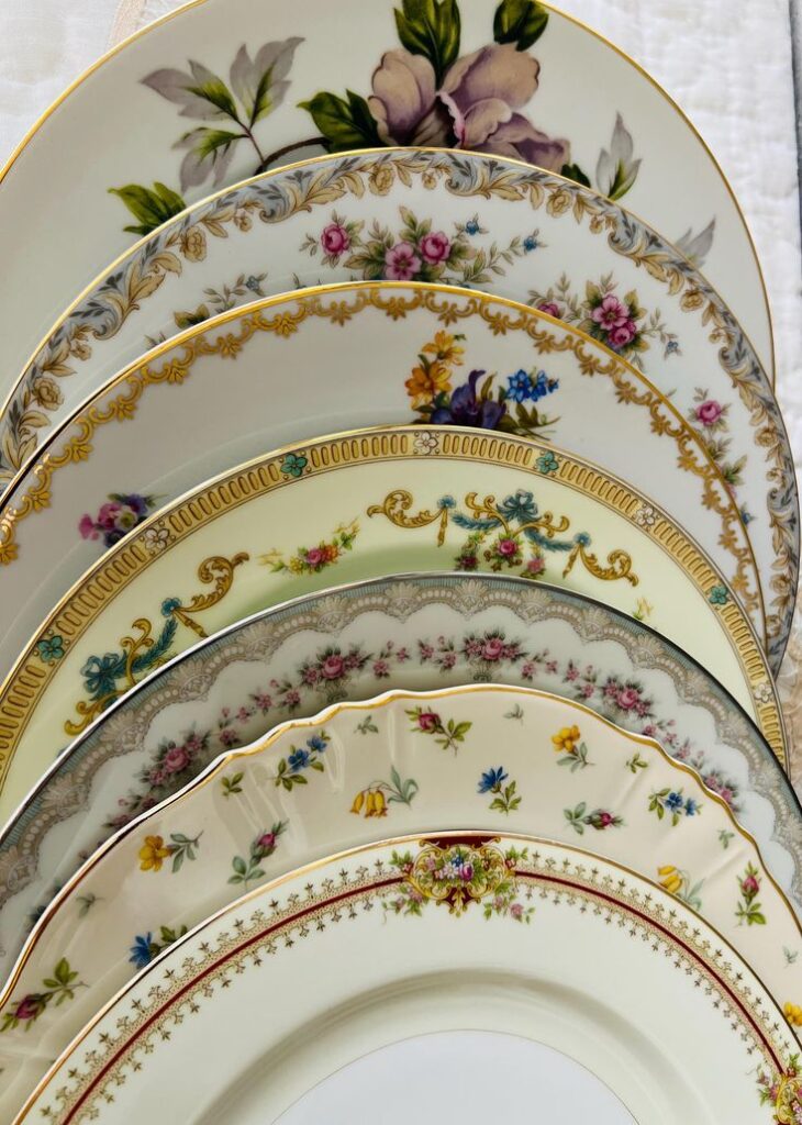 Elegant vintage floral china plates stacked, showcasing intricate patterns and delicate gold accents.