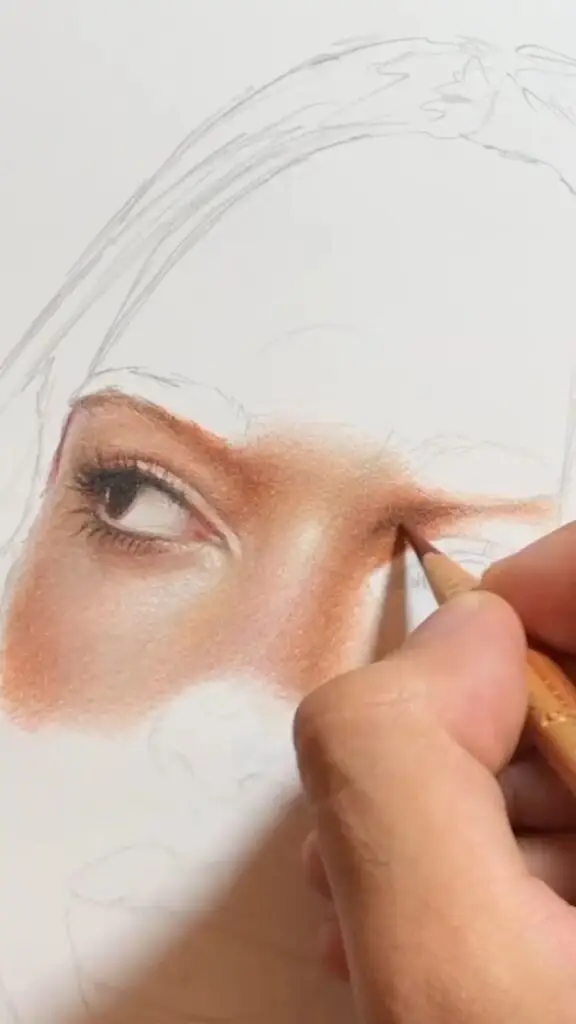Artist drawing realistic eye with colored pencils on paper.