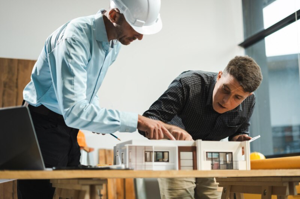 Architects discussing a building model in an office, focused on design details.