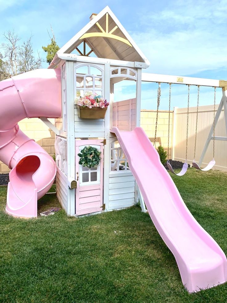 Whimsical backyard playhouse with pink slide and swingset, perfect for children’s outdoor fun and imaginative play.