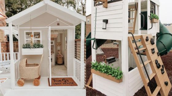 Charming white children's playhouse with a slide and climbing wall, surrounded by greenery and outdoor toys.