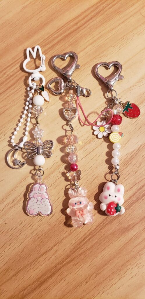 Cute keychains with heart, butterfly, and bunny designs on a wooden surface. Perfect for adding charm to your keys.