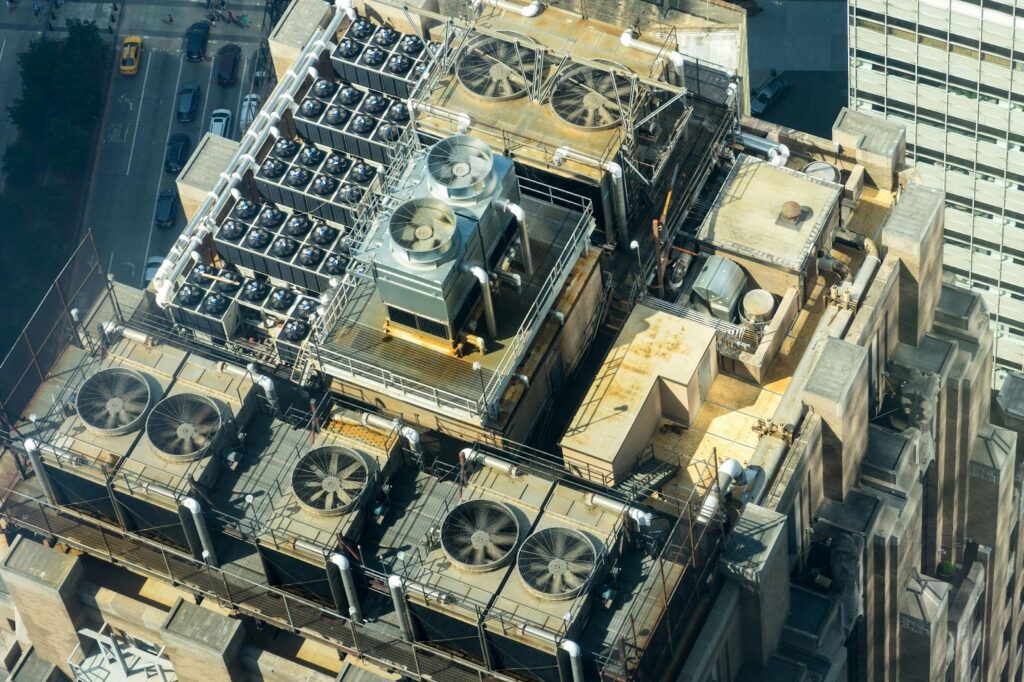 Aerial view of rooftop HVAC units on a city building, showing cooling systems and industrial equipment.