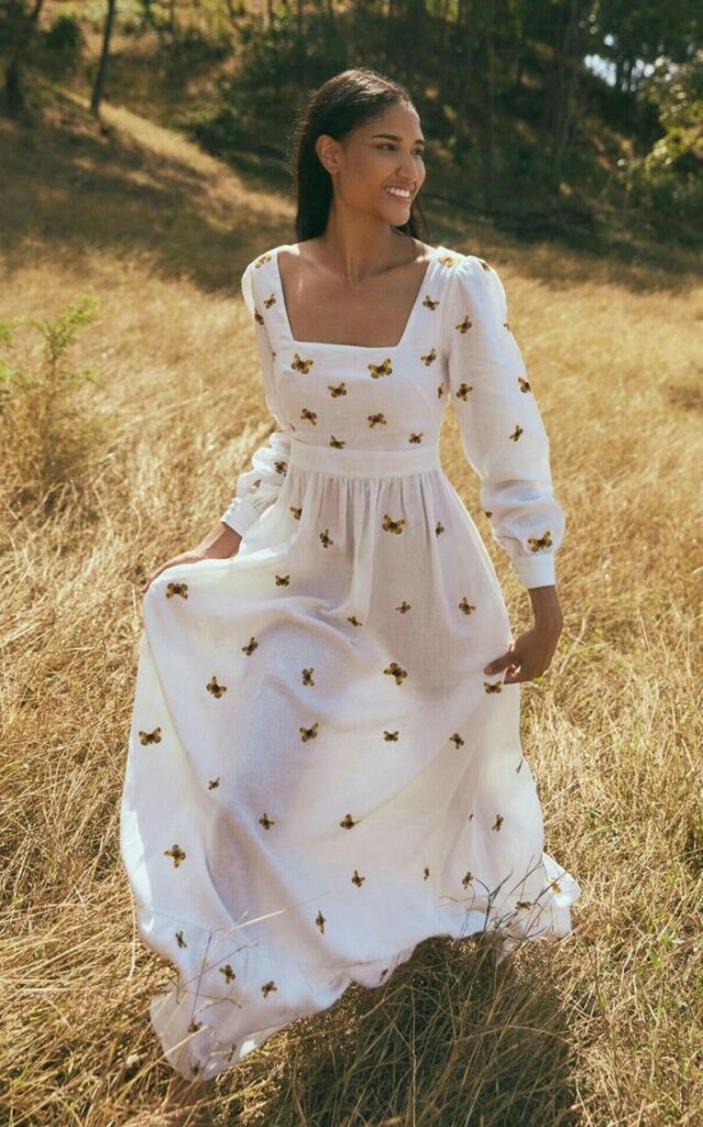 ▷ 1001 + modèles de robe longue champêtre pour lété Woman in white floral dress smiling in sunny meadow. | Sky Rye Design Woman in white floral dress smiling in sunny meadow.
