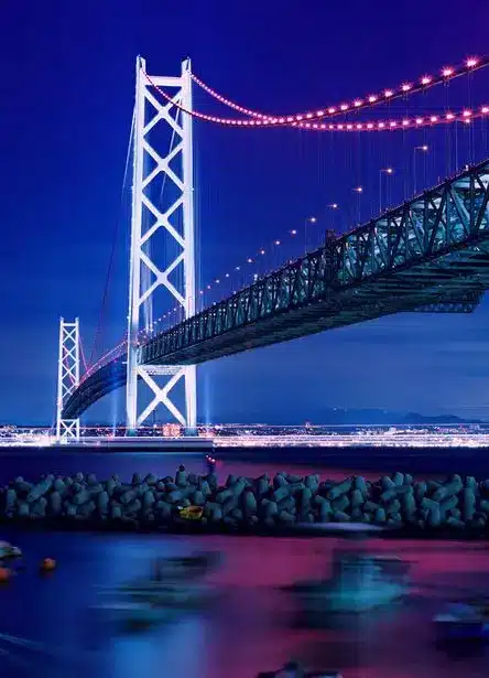 明石海峡_jpg _ GANREF Illuminated suspension bridge at night over calm waters, against a vibrant blue-purple sky. | Sky Rye Design Illuminated suspension bridge at night over calm waters, against a vibrant blue-purple sky.