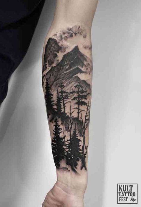 Forearm tattoo featuring a detailed mountain and forest scene with pine trees and clouds, showcasing natural beauty.