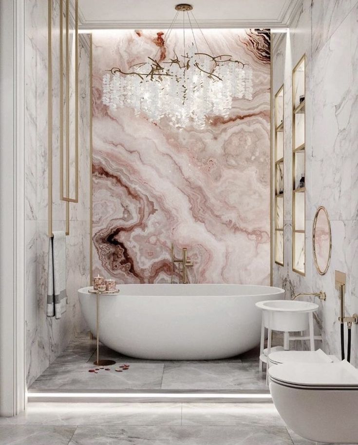 Luxurious marble bathroom with freestanding tub, chandelier, and elegant decor.