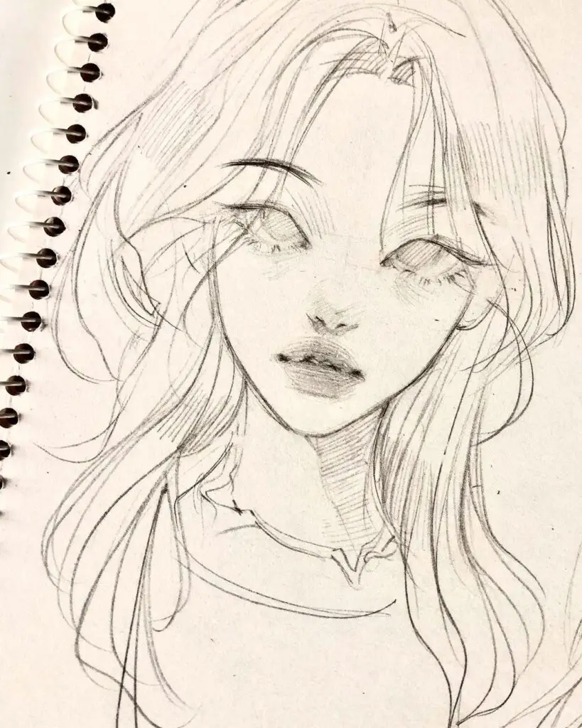 Sketch of a woman's face with long hair on a spiral-bound notebook page.