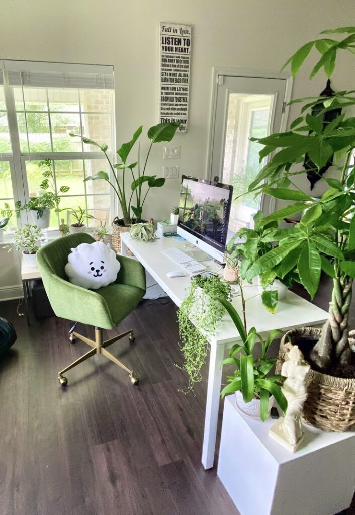 Stylish home office with green chair, desk, computer, and abundant indoor plants for a refreshing work environment.