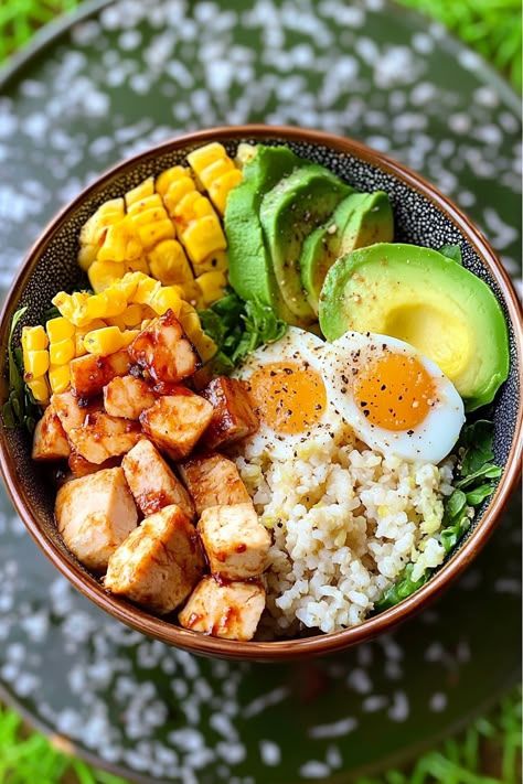 Healthy poke bowl with chicken, avocado, corn, boiled eggs, and rice on a vibrant green background.