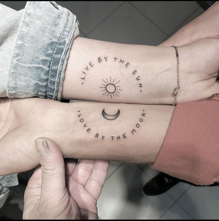 Matching tattoos: Live by the Sun and Love by the Moon on wrists, featuring sun and moon symbols.