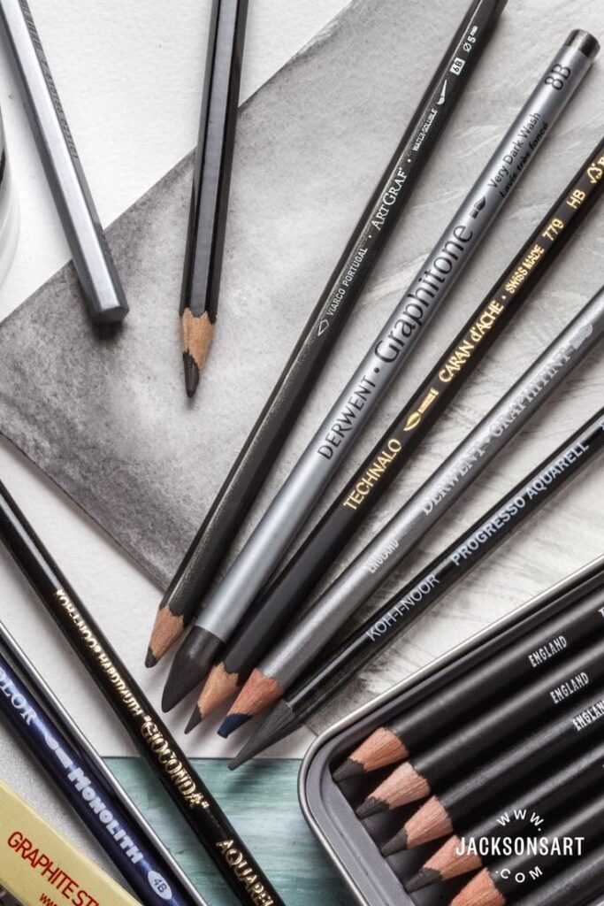 Various graphite pencils arranged on paper, featuring different shades and brands, ideal for sketching and drawing.